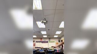 Busty MILF teacher dancing in her classroom.